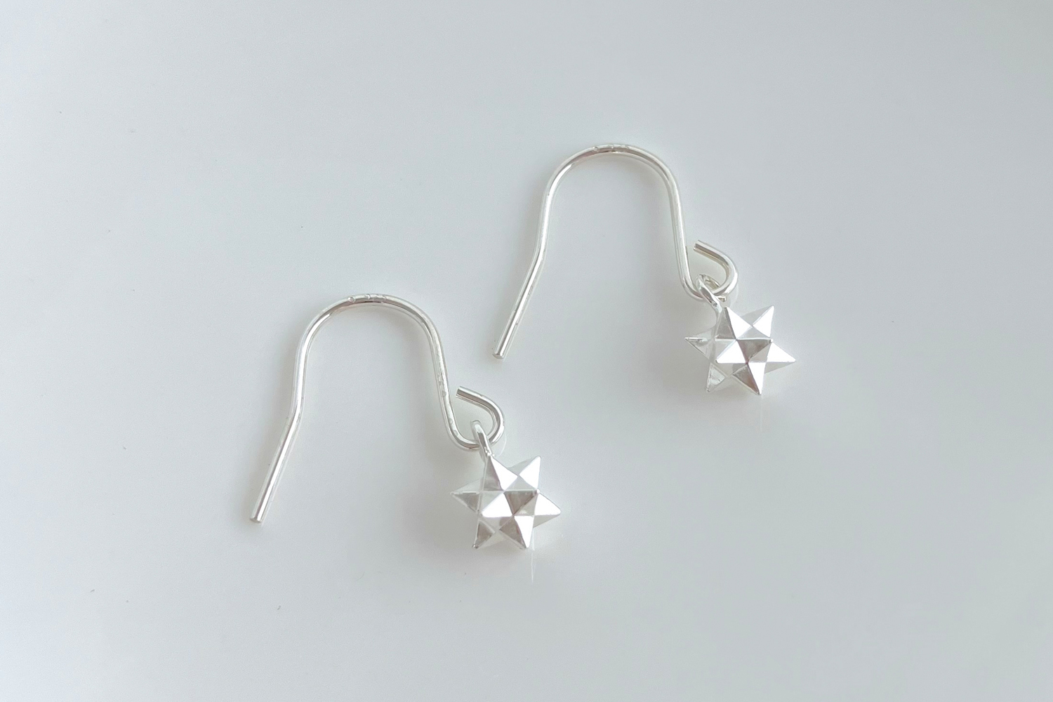 揺れるきらめく小さな星のフックピアス